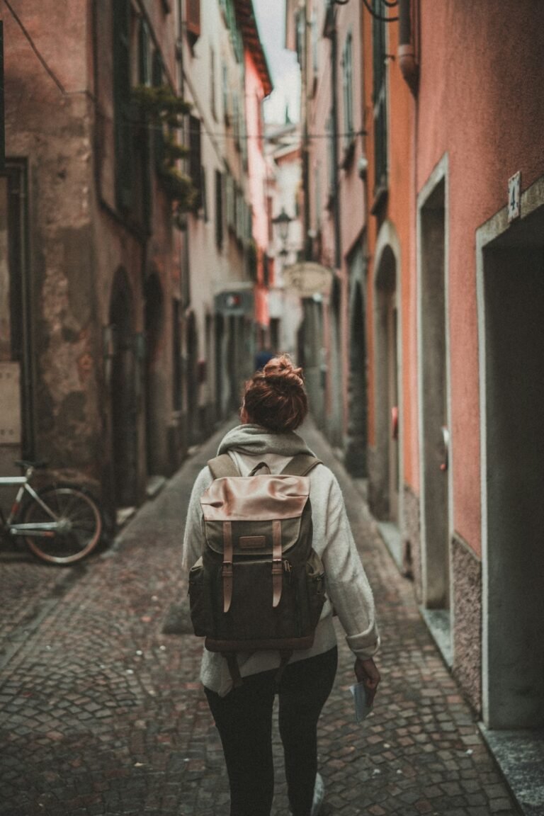 Traveller with a backpack at an airport window, insured by a nomad travel medical plan